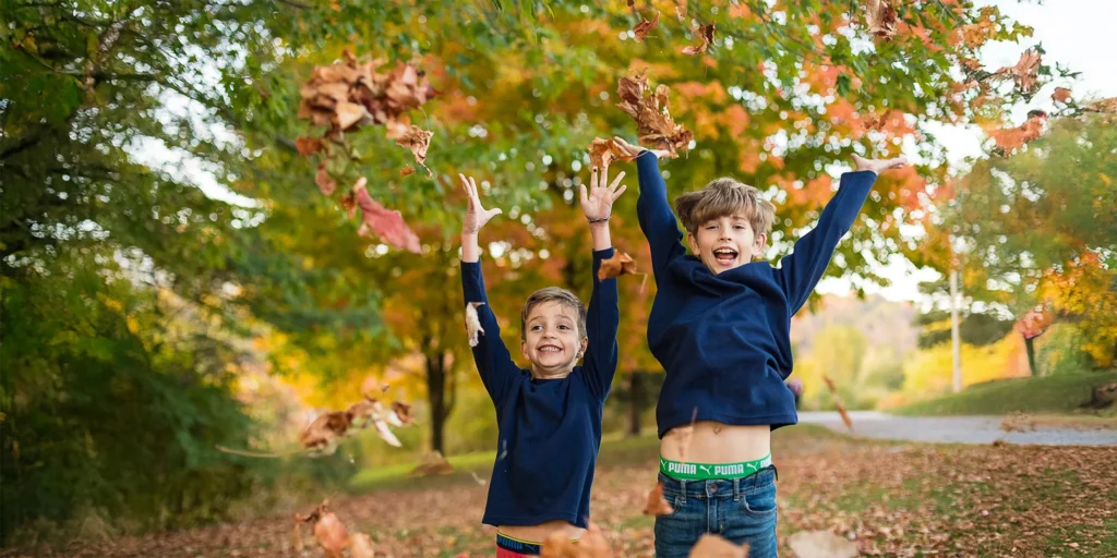 Boys throwing leaves byToronto family photogapher