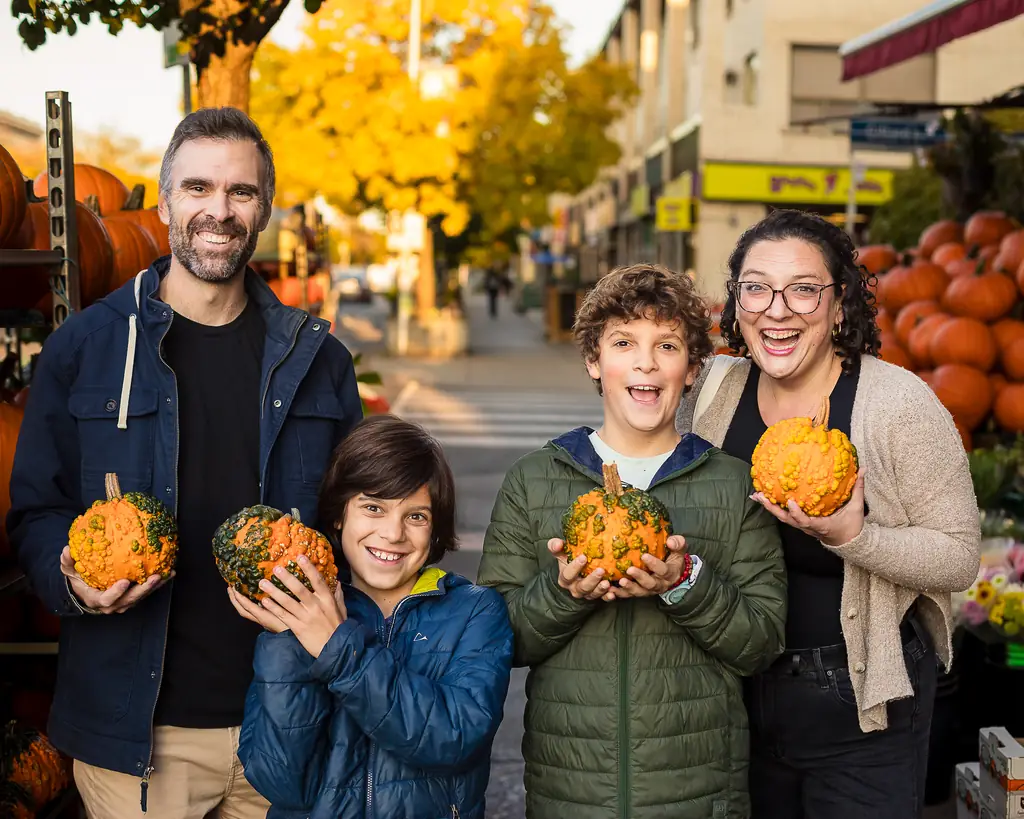 Family picking out pumpkins for Halloween along the Danforth in East York during a fall photo session