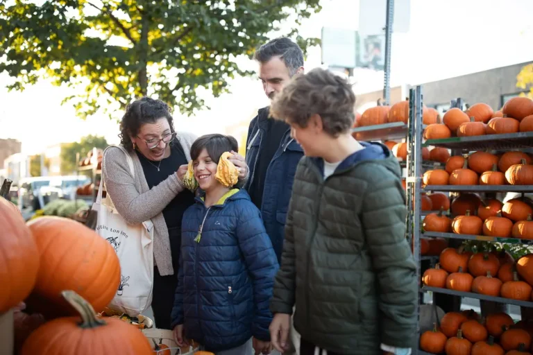 Brothers pumpkin shopping with their parents during a fall family photo session on the Danforth