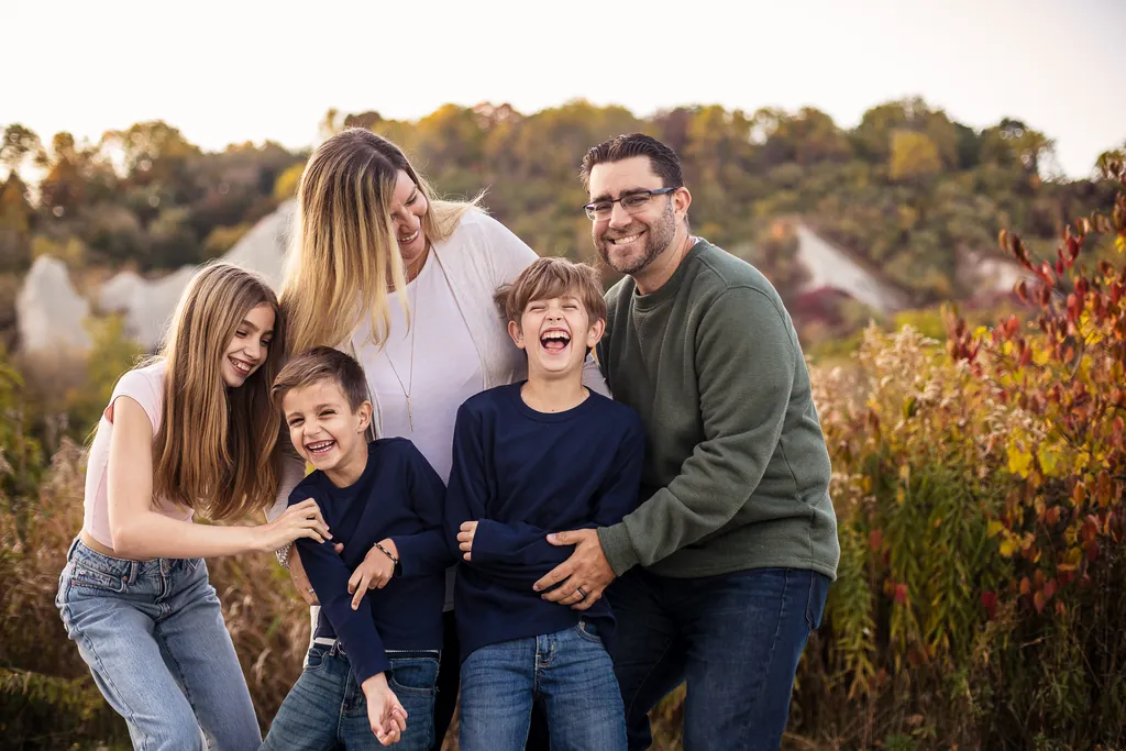 Family photo session at Scarborough Bluffs during fall with golden hour light and autumn leaves