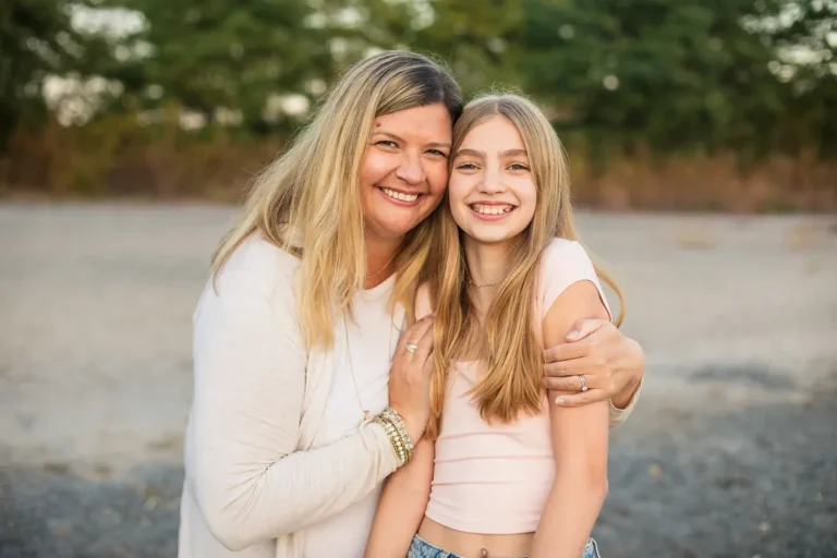 Mother and daughter smiling together on the beach at Scarborough Bluffs during a golden hour family photo session