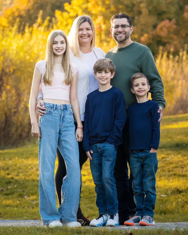 Traditional family portrait at Scarborough Bluffs with vibrant fall foliage in the background
