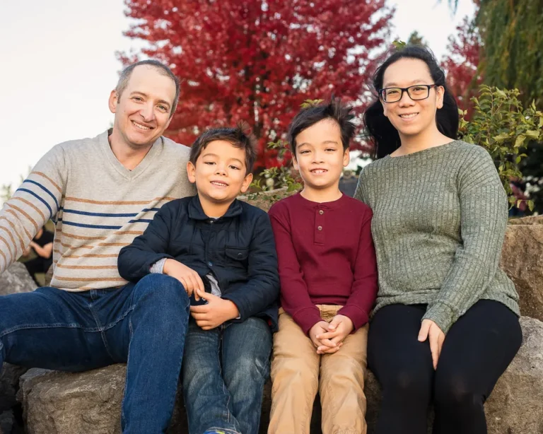 Fall family portrait with red tree in background taken by toronto family photographer.