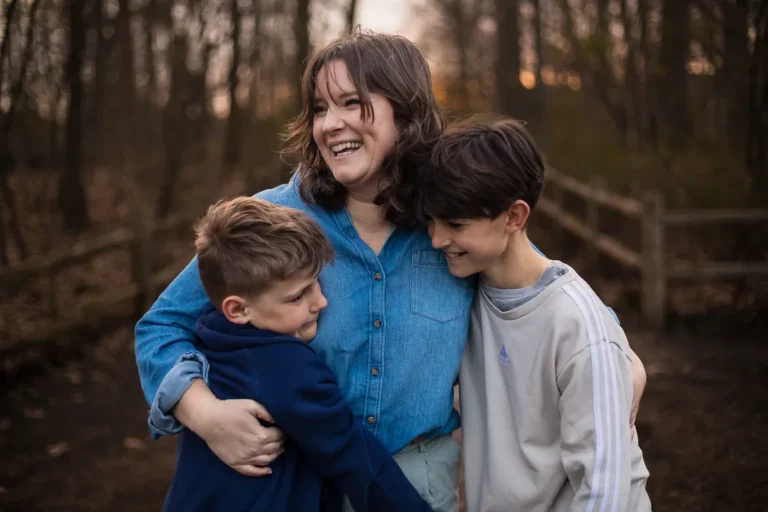 Mom hugging her two boys during a warm evening family photo session in Toronto's Kew Gardens